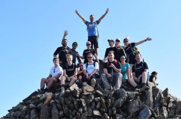 group of people on mountain summit fundraising for charity